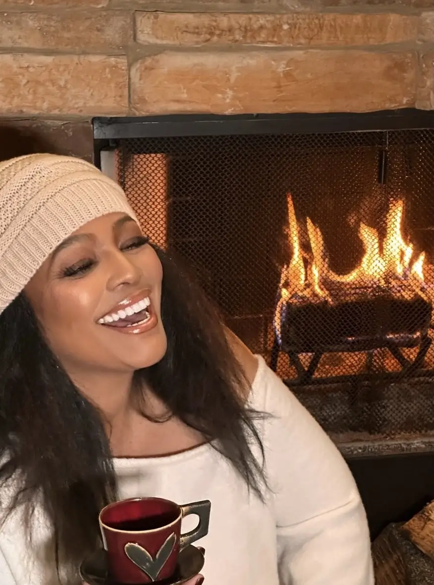 Kim in winter white, laughing by the fire